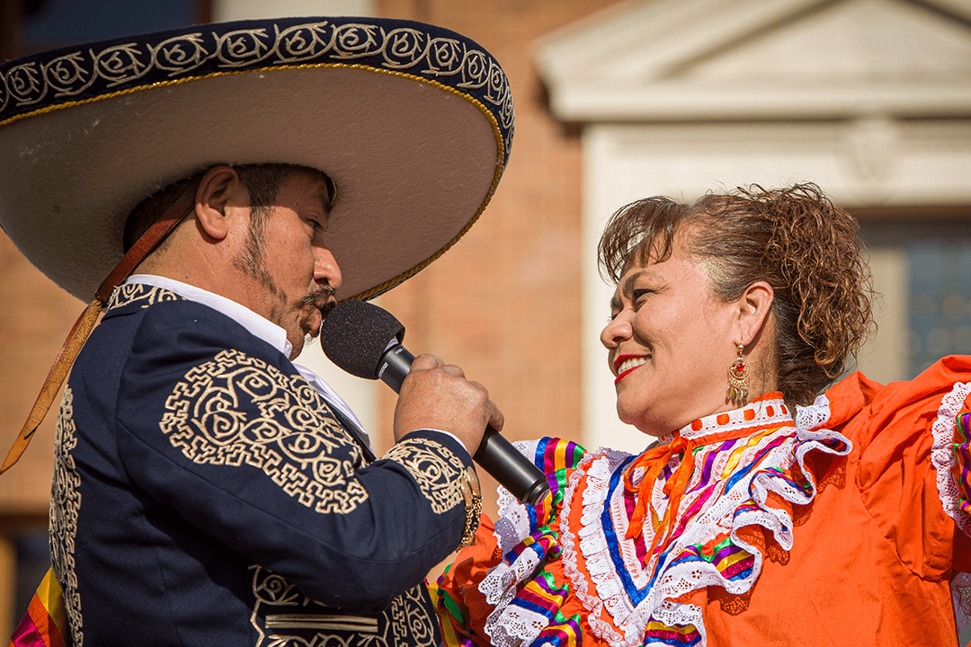 Image of Ranchero Artist Manuel Enrique singing to a Folkloric Dancer in full traditional costume in front of Atascadero City Hall - Photo by Keith Bergher